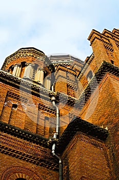 Abstract view of brown brick walls of Three Hierarchs Church against blue sky. Residence of Bukovinian and Dalmatian Metropolitans