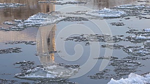 Abstract view of church reflection in the river stream in winter. Ice drift in the city. Urban architecture mirrored in the water