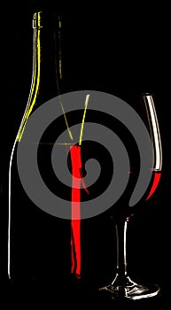 abstract view of a glass wine and the wine bottle against a solid black background.