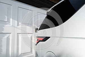 Abstract view of a parked SUV on a driveway close to garage doors