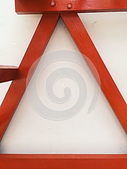 Abstract view of red wooden stairs at white wall at background