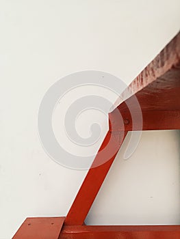 Abstract view of red wooden stairs at white wall at background