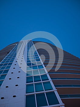 Abstract view on residential apartment complex building with many balconies and floors isolated against blue sky on sunny day