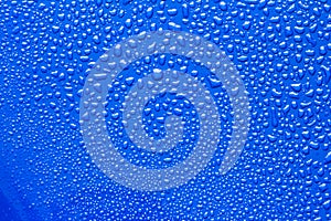 The Abstract water drop on surface of fresh blue background