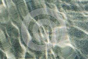 Abstract water ripple pattern in a swimming pool with a sun reflection