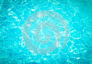 Abstract water in swimming pool. Shining sun reflection, motion of ripple wave. Background of water surface. Summer, sport, relax.