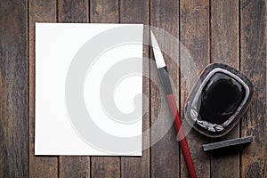 Abstract white paper with bamboo calligraphy brush and inkstone on old wooden table. picture for add text or greeting card chinese