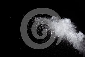 Abstract white powder explosion against black background.White dust exhale in the air