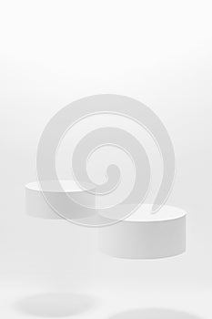 Abstract white scene mockup - two round white cylinder podiums, soar in hard light, shadow. photo