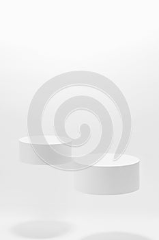 Abstract white scene mockup - two round white cylinder podiums, soar in hard light, shadow.