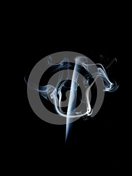 Abstract white smoke swirls on black background.