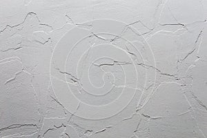 Abstract white unobtrusive background and texture. A plaster wall with old cracked layer under new one.