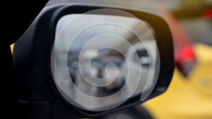 Abstract wing mirror view of car.