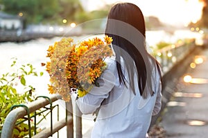 Abstract woman with bouquet flowers vibrant in hands on street and canal