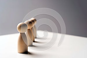 Abstract wooden toy figures stand in a row on a white background. Concept of employees in a team