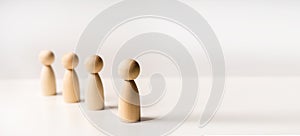 Abstract wooden toy figures stand in a row on a white background. Concept of employees in a team