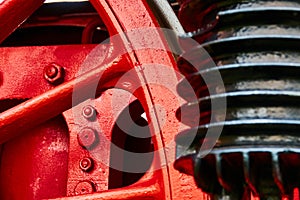 Abstract working detail at a historical black locomotive with a red iron wheel