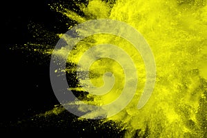 Abstract yellow dust explosion on black background.