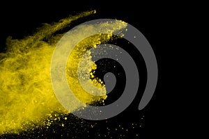 Abstract of yellow powder explosion on black background. Yellow