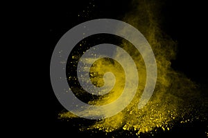 Abstract of yellow powder explosion on black background. Yellow powder splatted isolate. Colored cloud. Colored dust explode. Pain