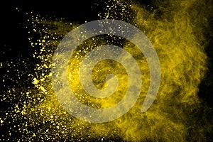 Abstract of yellow powder explosion on black background. Yellow powder splatted isolate. Colored cloud. Colored dust explode. Pain