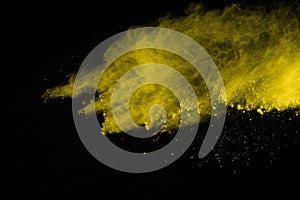 Abstract of yellow powder explosion on black background. Yellow powder splatted isolate. Colored cloud. Colored dust explode. Pain