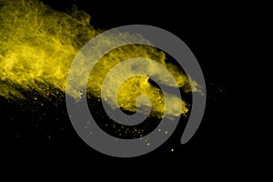 Abstract of yellow powder explosion on black background. Yellow powder splatted isolate. Colored cloud. Colored dust explode. Pain