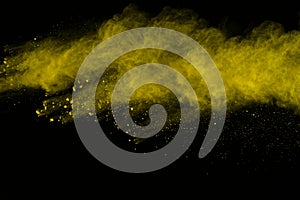 Abstract of yellow powder explosion on black background. Yellow powder splatted isolate. Colored cloud. Colored dust explode. Pain