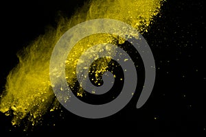 Abstract of yellow powder explosion on black background. Yellow powder splatted isolate. Colored cloud. Colored dust explode. Pain