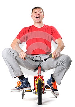 Absurd male on a children's bicycle