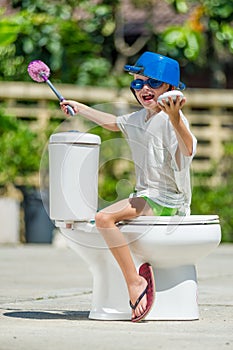 Absurd picture - astride a toilet: cute boy in goggles sitting o