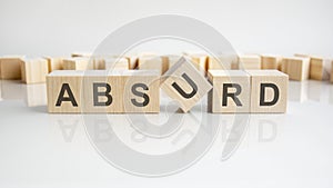 absurd text on a wooden blocks, gray background.