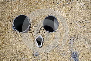 Abtract scene of three pipes in ciment forming a weird face photo