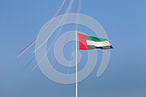 ABU DHABI, UAE - DECEMBER 02, 2017: Al Fursan aerobatic team flying over UAE flag in Abu Dhabi