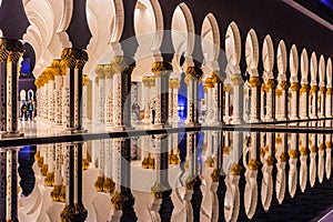 ABU DHABI, UAE - OCTOBER 17, 2021: Night view of the colonnade of Sheikh Zayed Grand Mosque in Abu Dhabi, United Arab