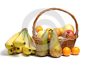 Abundance fruits white background in wicker basket, apples, pears, citrus fruits and bananas