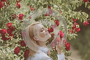 Abundant flowering. girl with red flowers in summer garden. Adorable girl with flower bloom. Pretty girl at