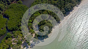 Abundant nature of white beach and forest all around the mountain in the open sky day by angle view from top view drone.