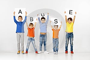 Abuse. Group of children with a banners isolated in white