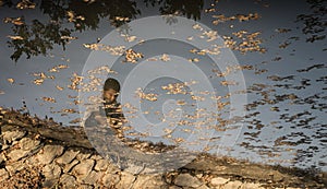 Abused child reflection on water