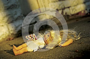 Abused doll lying on ground