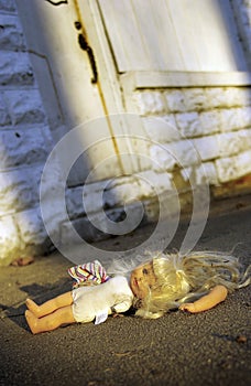 Abused doll lying on ground photo