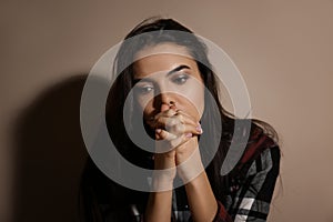 Abused young woman near wall. Domestic violence concept