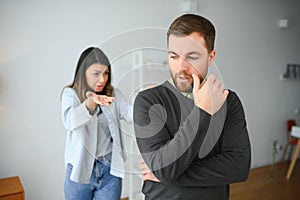 Abusive wife arguing husband, jealous distrustful dominant woman shouting at sad man