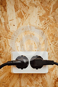 AC power plug and socket, wooden osb background