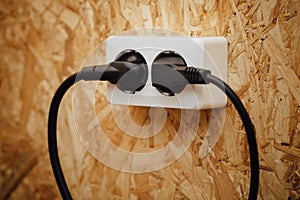 AC power plug and socket, wooden wall background