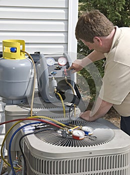 AC Repairman Charges Unit With Freon photo