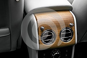 AC Ventilation Deck in Luxury modern car Interior. Modern car white leather interior. with stitching. Natural wood. Perforated lea