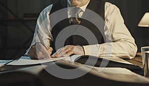 Academic professor writing down notes and reading a book