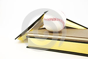 Academics and sports seen in books and baseball still life